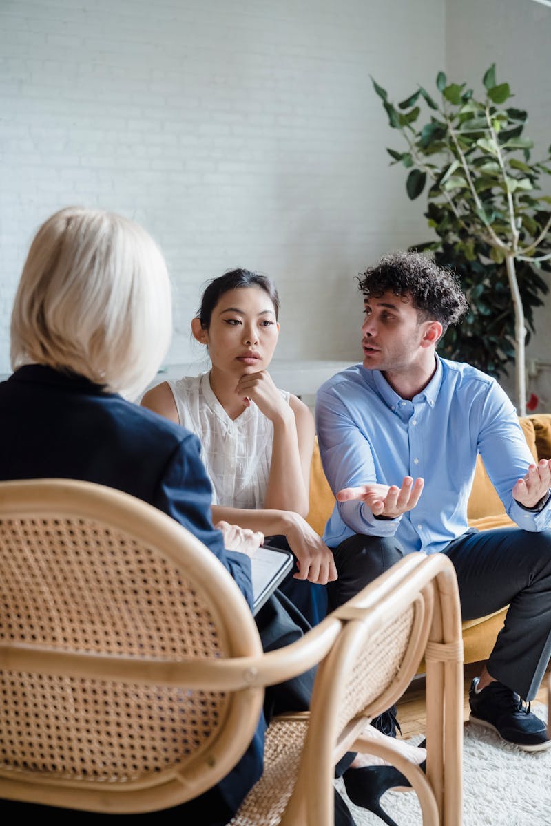 A couple discusses issues with a therapist in a modern office setting.